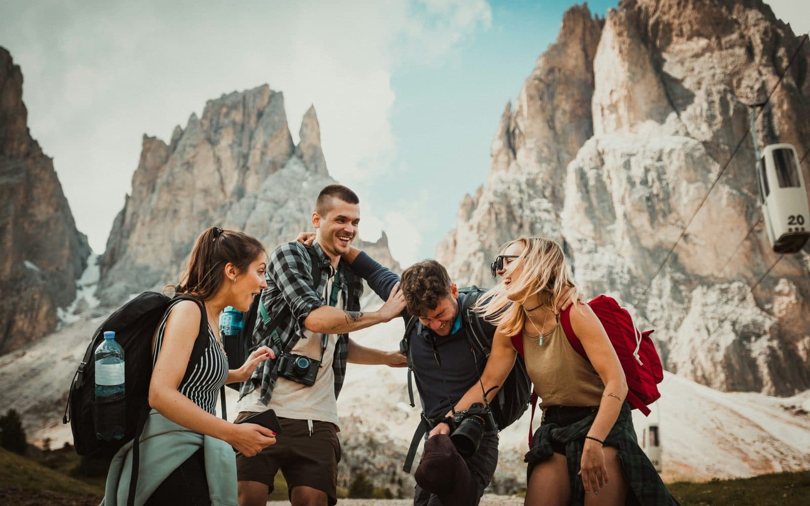 Des amis en randonnée qui rient au pied des montagnes